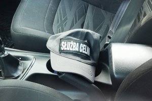 czapka z napisem służba celna leżąca pomiędzy fotelami samochodu