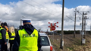 przejazd kolejowy policjant i funkcjonariusze SOK stoją obok samochodu