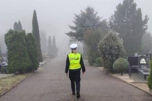 policjantka spaceruje uliczkami cmentarza