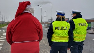 policjanci stoją tyłem obok mikołaj