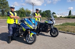 policjanci wydziału ruchu drogowego przy motocyklach służbowych, patrolują bezpieczeństwo w ruchu drogowym.