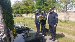 Policjanci składają wieniec na pomniku policjanta.