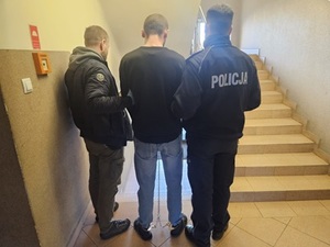 policjanci prowadza zatrzymanego mężczyznę.