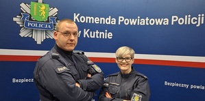 Policjanci na tle napisu Komenda powiatowa policji w Kutnie.