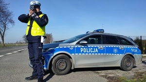 policjant kontrolujący prędkość pojazdów na drodze.