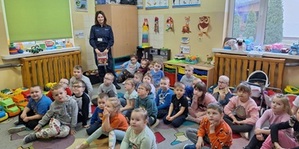 policjantka z dziećmi z przedszkola podczas prelekcji.