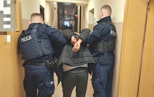policjanci prowadzą zatrzymanego mężczyznę.
