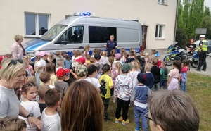 policjantka z dziećmi przy radiowozie.
