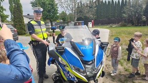 policjant z dziećmi przy motocyklu.