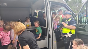 policjant z dziećmi przy radiowozie.