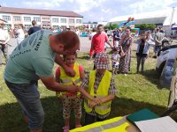 mężczyzna zakłada dzieciom kamizelki odblaskowe