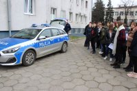 dni otwarte w łowickiej komendzie, uczniowie oglądają na dziedzińcu komendy radiowóz.