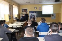 policjanci rozmawiają z uczniami o  zawodzie policjanta w szkole.