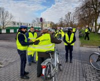 policjanci i przedstawiciele stowarzyszenia wręczają kamizelki odblaskowe.