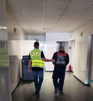 policjant prowadzi zatrzymanego