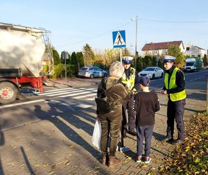 policjanci z ruchu drogowego rozdają odblaski.