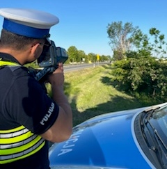 policjant z ruchu drogowego kontroluje prędkość pojazdów.