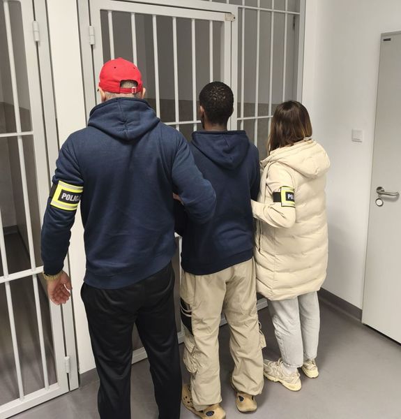 nieumundurowani policjanci prowadzą zatrzymanego.