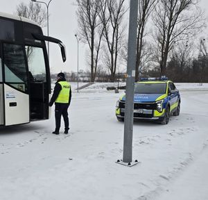 policjant kontroluje autokar.