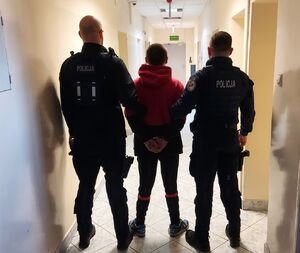 policjanci prowadzą zatrzymanego.