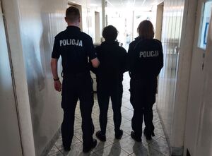 policjanci prowadzą zatrzymanego.