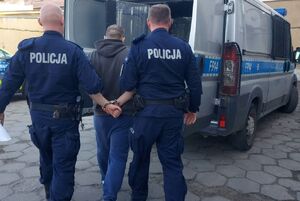 policjanci prowadzą zatrzymanego.
