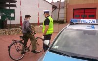 policjant wręcza maseczkę rowerzyście