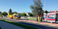 pracujące służby ratunkowe na miejscu wypadku drogowego: straż pożarna, śmigłowiec Lotniczego Pogotowia Ratunkowego, służby medyczne