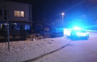 policyjny radiowóz stojący przy posesji, gdzie uszkodzony został płot oraz narożnik domu przez volkswagena , który również jest widoczny na zdjęciu