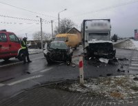 umundurowany policjant pracujący na miejscu wypadku drogowego. Na drodze znajdują się trzy uszkodzone samochody, które uczestniczyły w zdarzeniu.