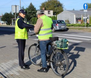 policjantka wręcza rowerzyście kamizelkę odblaskową