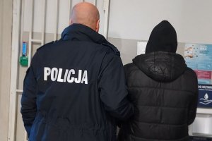 policjant prowadzi zatrzymanego