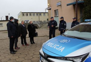 nowy oznakowany radiowóz stoi na parkingu przed Komendą Powiatową Policji w Wieluniu. Wokół stoją policjanci i przedstawiciele władz samorządowych.