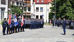 Międzypowiatowe Obchody Święta Policji na Placu Kazimierza Wielkiego w Wieluniu stoi kompania honorowa garnizonu łódzkiego, poczty sztandarowe, dowódca uroczystości wydaje komendy.