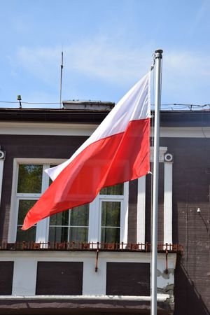 Powiewająca na maszcie flaga Rzeczypospolitej Polskiej.