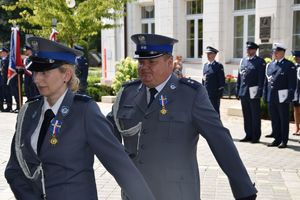 Policjanci wstępują na trybunę honorową po wręczeniu odznaczenia.