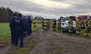 Policjanci i strażacy w miejscu koncentracji sił w miejscu gdzie będą prowadzone poszukiwania zaginionego.
