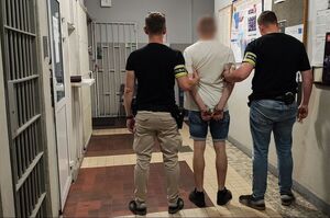 Policjanci prowadzą zatrzymanego.