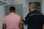 policjant osadzający zatrzymanego w policyjnej celi