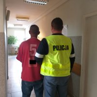 policjant prowadzi zatrzymanego