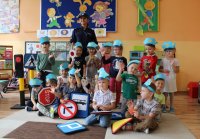 policjantka z przedszkolakami w trakcie pogadanki edukacyjno- profilaktycznej na temat bezpieczeństwa