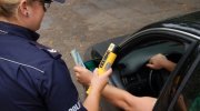 Policjantka bada kierowcę na zawartość alkoholu w wydychanym powietrzu