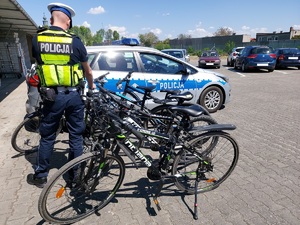 policjant przy zabezpieczonych rowerach.