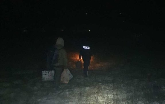 widzimy idąca osobę wraz z policjantem po polu.