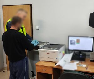 Policjant stoi z zatrzymanym.