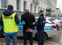 policjanci prowadzą zatrzymanego sprawce kolizji, który uciekł z miejsca zdarzenia, został zatrzymany po pościgu