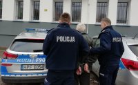 policjanci prowadzą  zatrzymanego