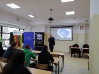 policjant w czasie spotkania z młodzieżą w szkole. Wykład poświęcony doborowi do służby w policji oraz profilaktyce.