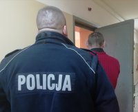 policjant prowadzi zatrzymanego