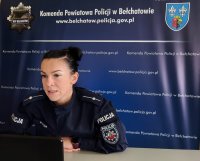 policjantka w czasie spotkania online . siedzi przy komputerze w  pomieszczeniu komendy policji